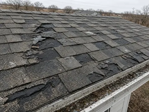 Hail-damaged asphalt shingles with missing pieces